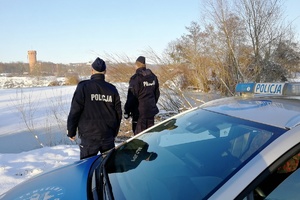 Policjanci obserwują zamarznięty zbiornik wodny