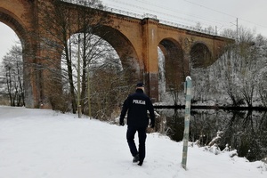 Policjant sprawdza rejon rzeki w miejscowości Kozłowo