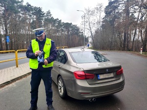 Policjant obsługuje urządzenie do pomiaru prędkości