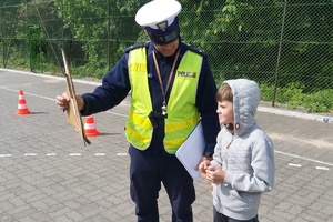 Policjant tłumaczy chłopcu zasady pokonywania toru