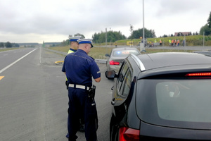 Policjanci kontrolują zatrzymany pojazd
