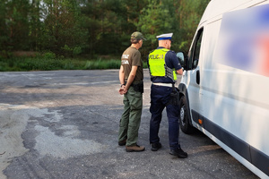 Mundurowi sprawdzają dokumenty zatrzymanego do kontroli kierowcy