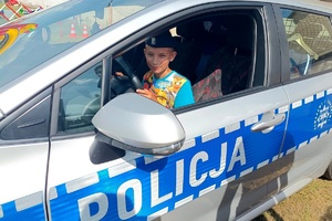 W radiowozie policyjnym siedzi chłopiec