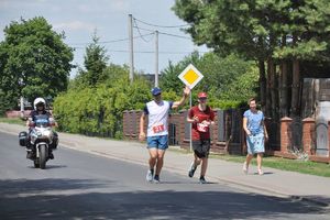 Policjant na motocyklu zabezpiecza tył wyścigu