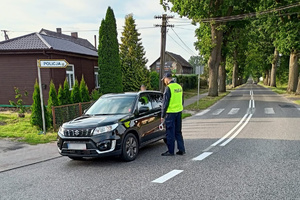 Policjant podchodzi do samochodu aby sprawdzić trzeźwość kierowcy