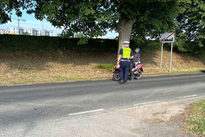 Policjant kontroluje motorowerzystę