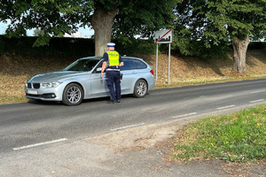 Policjant ruchu drogowego podchodzi do kierowcy aby sprawdzić jego trzeźwość