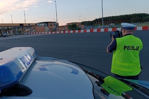 Policjant mierzy prędkość w rejonie bramek autostradowych