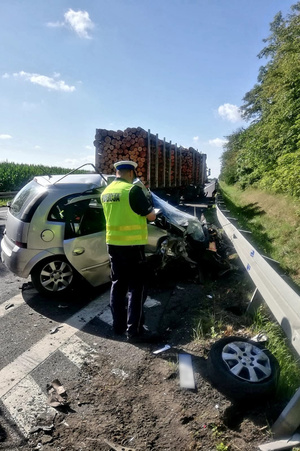 Policjant ruchu drogowego wypisuje dokumentację związana ze zdarzaniem na drodze