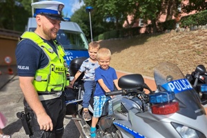 Na policyjnym motocyklu siedzi dwóch chłopców