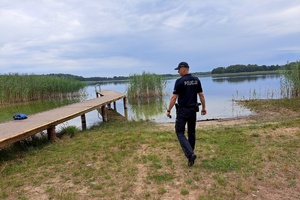 Policjant kontroluje niestrzeżoną plażę nad jeziorem