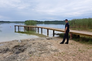 Policjant obserwuje płynącą jeziorem osobę