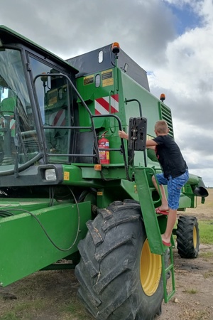 Chłopiec wchodzi na urządzenie rolnicze