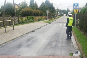 Policjant ruchu drogowego sprawdza widoczność znaków drogowych