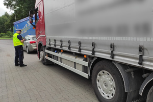Funkcjonariusz drogówki sprawdza dokumenty kierowcy ciężarówki