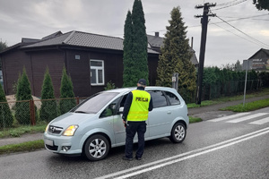 Policjant drogówki sprawdza trzeźwość kierowcy auta