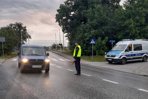 Policjant wskazuje kierowcy miejsce zatrzymania pojazdu do kontroli