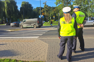 Funkcjonariusze pomagają dzieciom przechodzić przez jezdnię