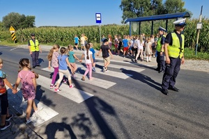 Policjanci przeprowadzają dzieci przez jezdnie