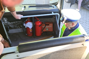 Policjant sprawdza obowiązkowe wyposażenie autobusu