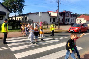 Uczniowie ćwiczą pod okiem policjantów przechodzenie przez jezdnię