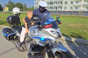 Chłopiec siedzi na motocyklu policyjnym