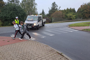 Policjant ręką wskazuje kierowcy miejsce zatrzymanie pojazdu