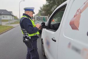 Mundurowy rozmawia z zatrzymanym do kontroli kierowcą