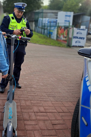 Policjant kontroluje kierując hulajnogą