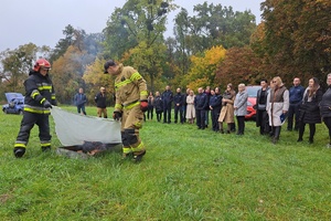 Strażacy prezentują gaszenie pożaru za pomocą koca gaśniczego