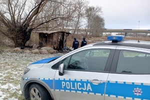 Policjanci stoją w pobliżu pogorzeliska