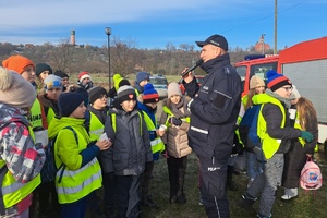 Policjant rozmawia z uczniami w okolicy przepompowni wody