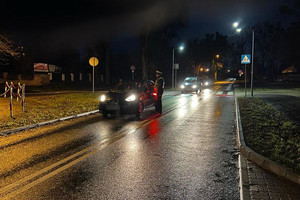 Policjant zatrzymał ruch pojazdów, kontroluje trzeźwość kierowców