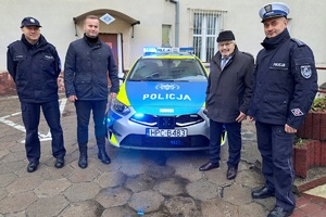 Policjanci i włodarze miasta pozują przez nowym radiowozem do zdjęcia