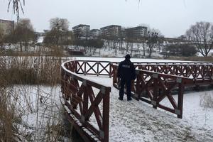 Policjant wchodzi na mostek na stawie