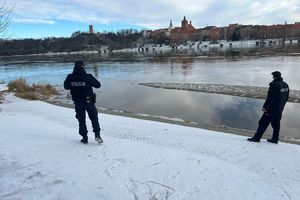 Policjanci obserwują brzeg zbiornika wodnego