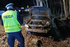 Policjant prowadzi oględziny uszkodzonego samochodu