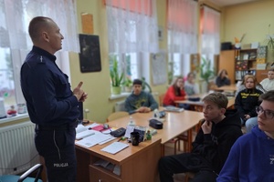 Policjant rozmawia z uczniami ósmej klasy