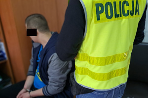 Policjant pilnuje zatrzymanego meżczyznę