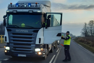 policjant bada trzeźwość kierowcy pojazdu ciężarowego