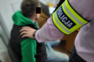 Policjant pilnuje zatrzymanego mężczyznę