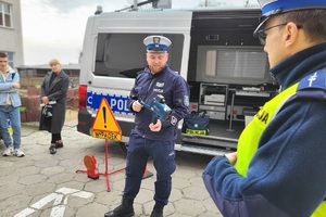 Policjant pokazuje zebranym sprzęt do mierzenia prędkości