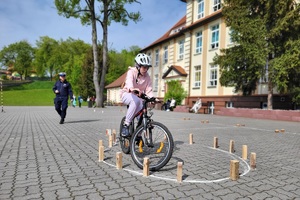 Dziewczynka pokonuje na rowerze przeszkodę