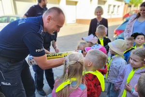 Policjant prezentuje dziecku działanie magicznej tuby