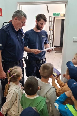 Policjanci odczytują laurkę otrzymaną od dzieci