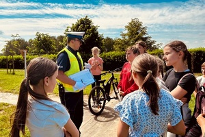 Policjant omawia z dziećmi popełnione na praktycznym egzaminie błędy