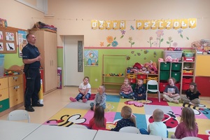 Policjant wita zgromadzone na spotkaniu dzieci
