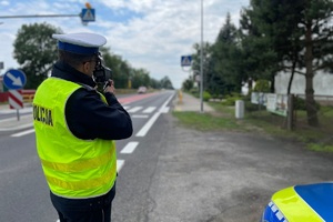 Policjant trzyma w ręku miernik prędkości