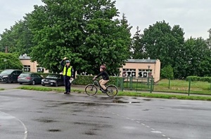 Policjant obserwuje rowerzystę podczas egzaminu
