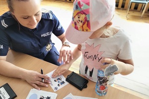 Policjantka wykonuje dziewczynce odciski palców